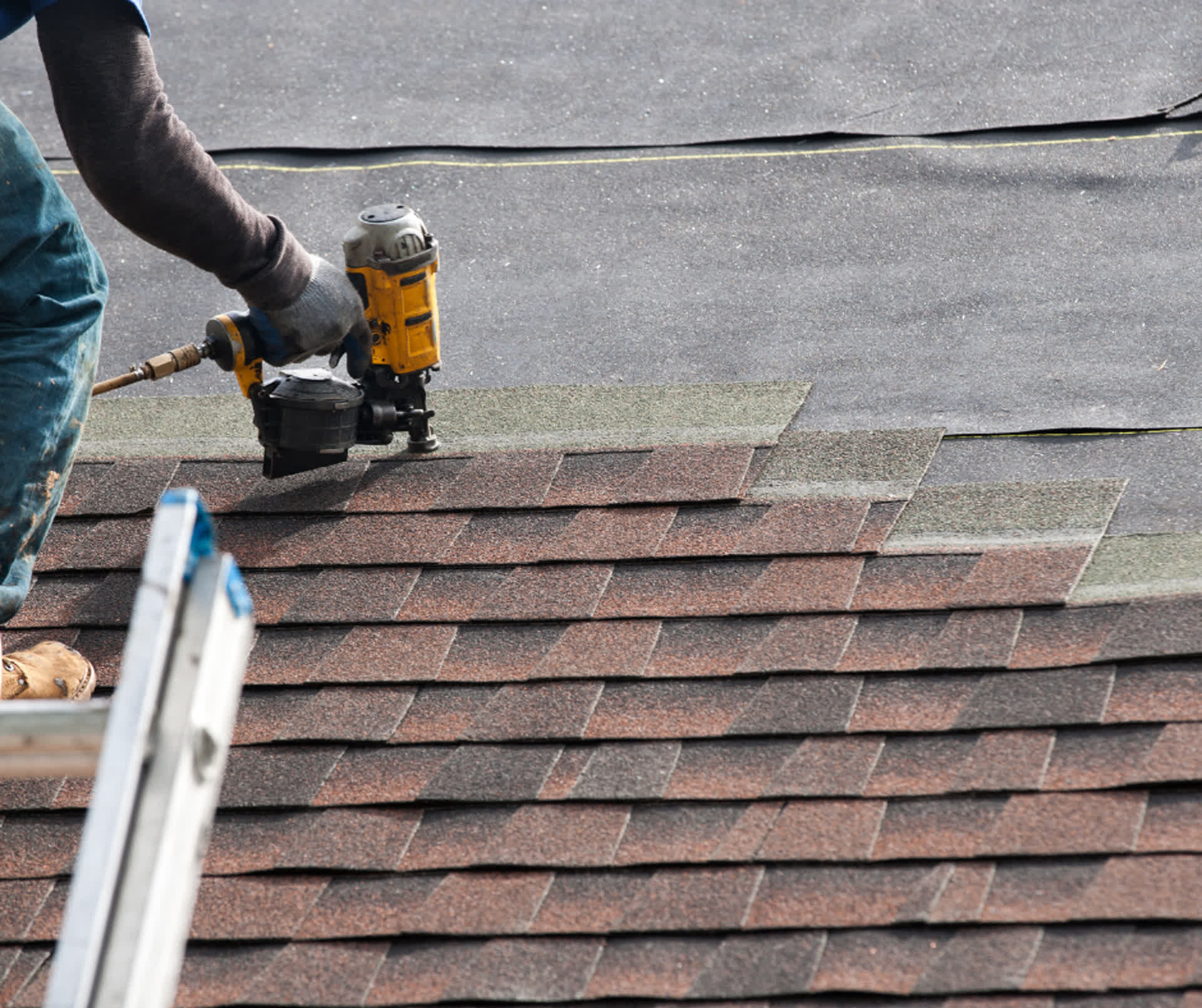 Close-up of roof repair work on asphalt shingles