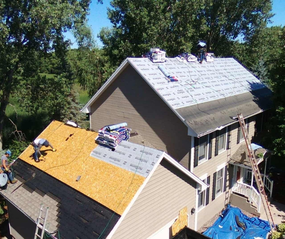 Roofers installing shingles on a residential home