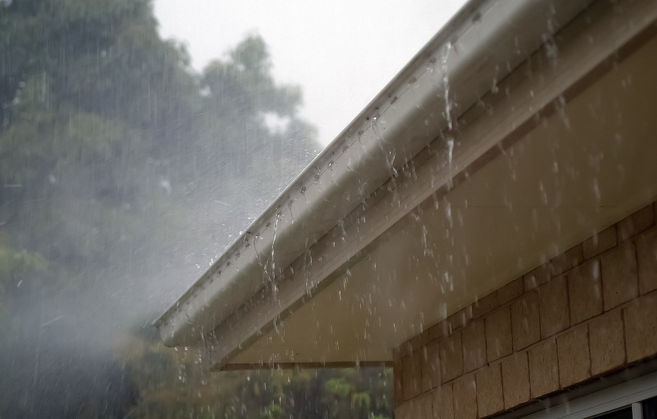 Rainwater running off roof indicating potential leak damage