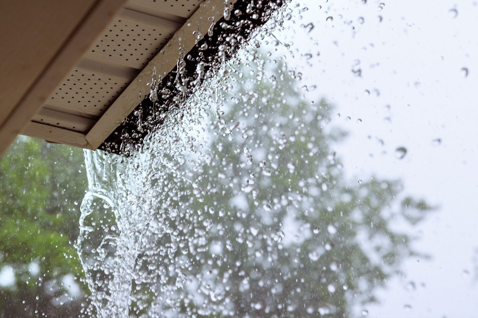 Water overflowing from clogged gutters during heavy rain — spring roof inspection, Roanoke