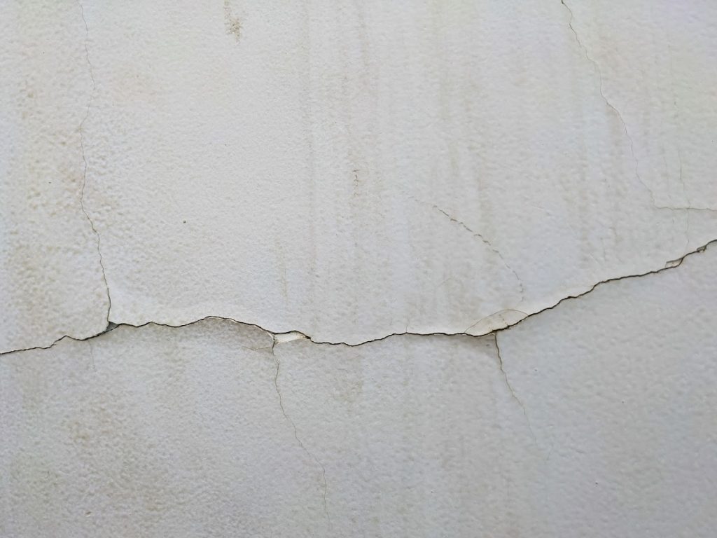 A wall damaged by water with cracked paint - winter roof damage